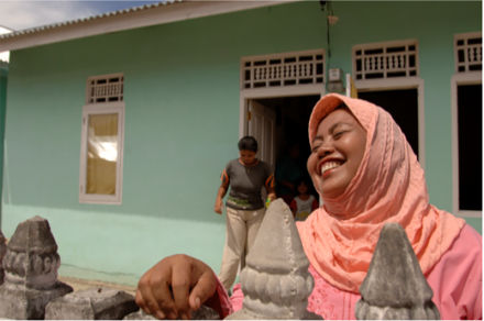 <p>Habitat homeowner Nuraini in front of her home, 2006<br />
Sigli, Indonesia</p>
<p>Founded in 1976, Habitat for Humanity is a global non-profit housing organization working across the United States and in more than 70 countries. Habitat volunteers help families to achieve strength, stability, and self-reliance through shelter. In the Pante Tengah area where Nuraini lives, the organization built 84 houses with families affected by the 2004 Indian Ocean tsunami.</p>
<p>© Habitat for Humanity International</p>
