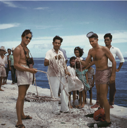 <p>Henri Rotschi (left) holds a basket used to collect pearl shells as researcher Willard Bascom and Paniora examine the weight line, 1952<br />
Location in Tonga unknown</p>
<p>The Scripps Institution of Oceanography at the University of California, San Diego, is one of the oldest and largest centers for ocean and earth science research in the world. As part of its Capricorn Expedition, scientists studied the Tonga Trench, the second deepest place in the ocean, and measured heat flow on the East Pacific Rise.</p>
<p>Scripps Institution of Oceanography Photograph Collection, bb8465282s</p>
