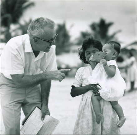 <p>William Vitarelli with a woman and baby, c. 1967-1969<br />
Ebeye, Marshall Islands<br />
Photograph by Robert Wenkam</p>
<p>William Vitarelli, known in Palau as Rubak, was an American educator and architect for the Trust Territory of the Pacific Islands. Between 1949 and 1970, he was stationed in the Marshall Islands, Palau, and Saipan. Throughout his career, Vitarelli organized a wide variety of educational and community development projects while advocating for locals’ rights.</p>
<p>Trust Territory Photo Archives, University of Hawaii-Manoa Library.</p>
