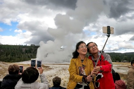 <p>Chinese tourists take a selfie in front of Old Faithful, 2018<br />
Yellowstone National Park, Wyoming<br />
<em>© David Cooper</em></p>
<hr>
<p>中国游客在老忠实泉前自拍，2018年<br />
怀俄明州黄石国家公园<br />
<em>© David Cooper</em></p>
