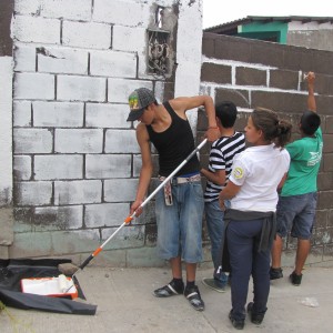Volunteers help prime the mural site