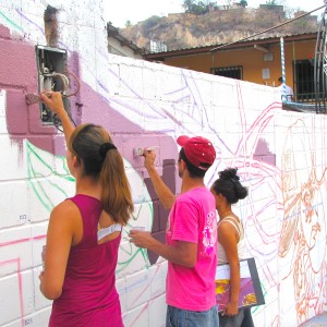 Volunteers apply paint to the mural