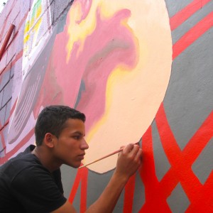 Volunteers apply paint to the mural