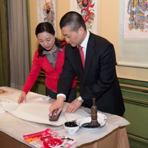 The Chinese Deputy Chief of Mission, Minister Lu Kang, and artist, Yang Huiping, demonstrate the process woodblock print making at the Chinese Lunar New Year celebration.