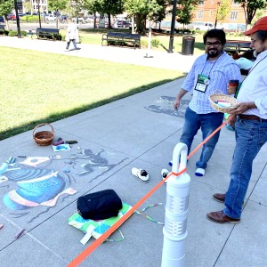 An IVLP participant explains his Chalk Slam art on freedom of the press to Matt Wuerker of Politico as part of the AAEC convention in Columbus, Ohio.