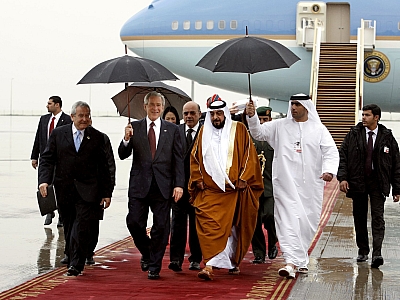 US President Bush holds an umbrella as he is escorted by President of  the UAE Sheikh Khalifa in Abu Dhabi