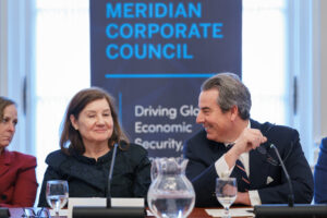 The Brazilian Ambassador and CEO of Meridian share a laugh. They are welcoming attendees and opening the program. 
